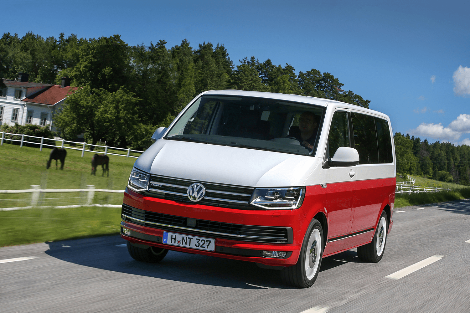 Picture of a red and white VW campervan driving down the road