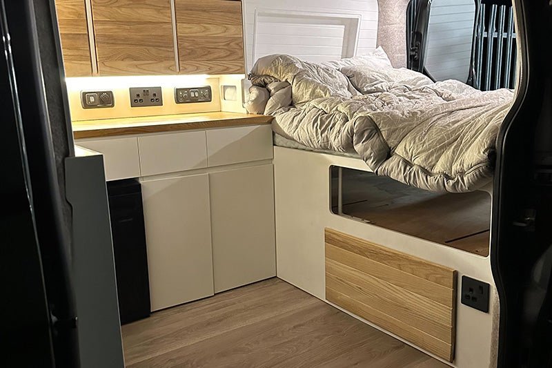 interior shot showing natural wood and white interior of a converted ford transit custom