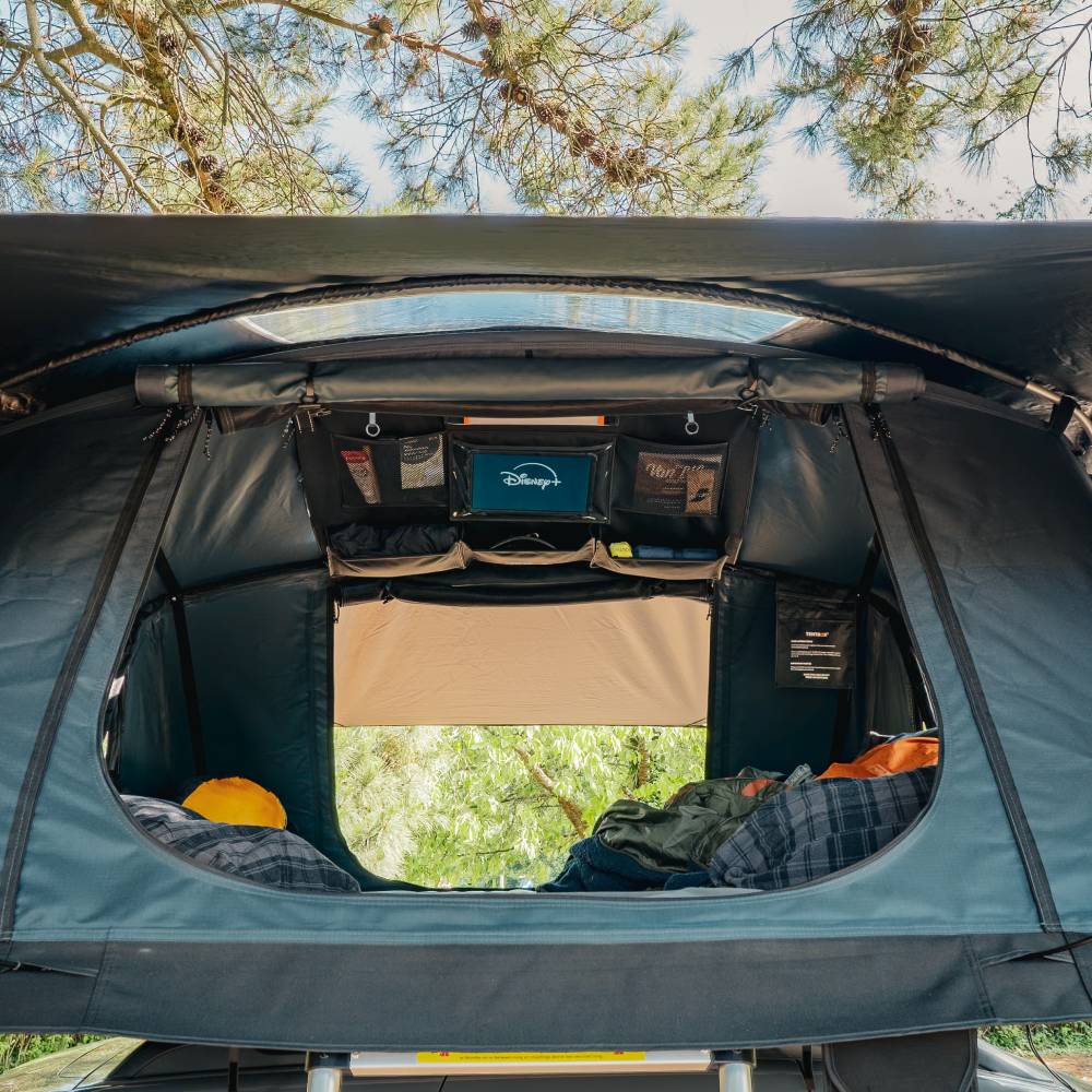 Black canvas TentBox Lite storage pockets with staggered sizes, velcro-backed, inside a rooftop tent.