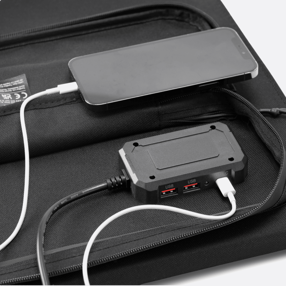 closeup of TentBox Solar Panl on white with mobile phone and devices charging