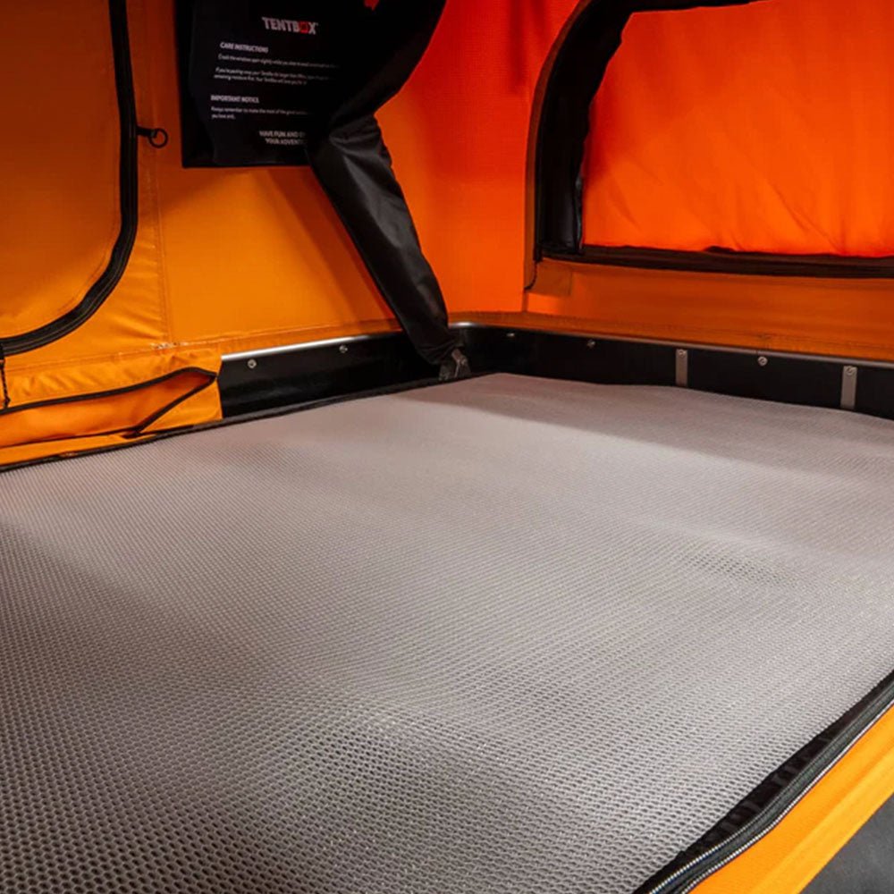 Light gray, textured ventilation mat for TentBox Classic 2.0, laid flat inside an orange tent.