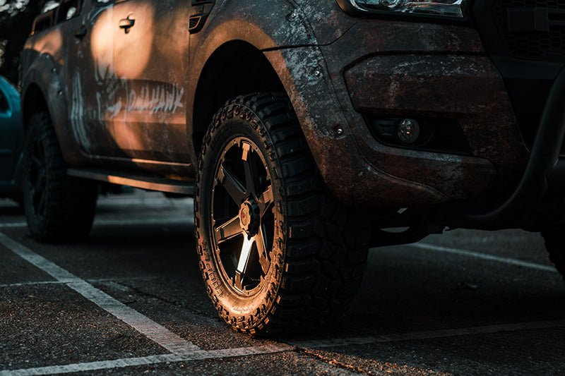 close up of swamper style wheels on a van at dusk