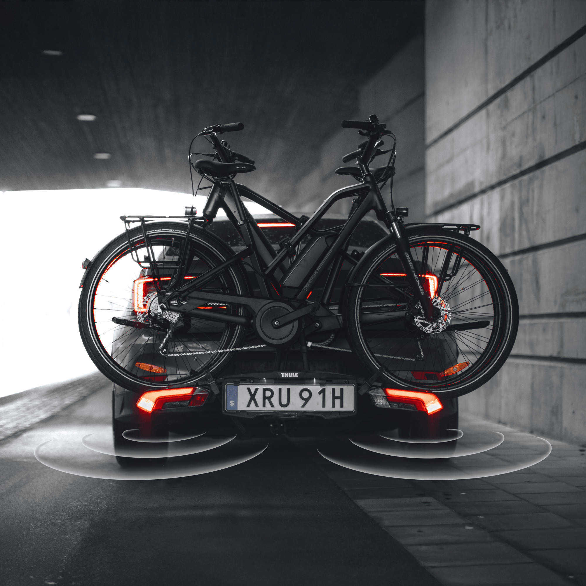Black Thule Epos ParkSecure 3B RHD towbar bike carrier with two bikes, showing parking sensor alerts.