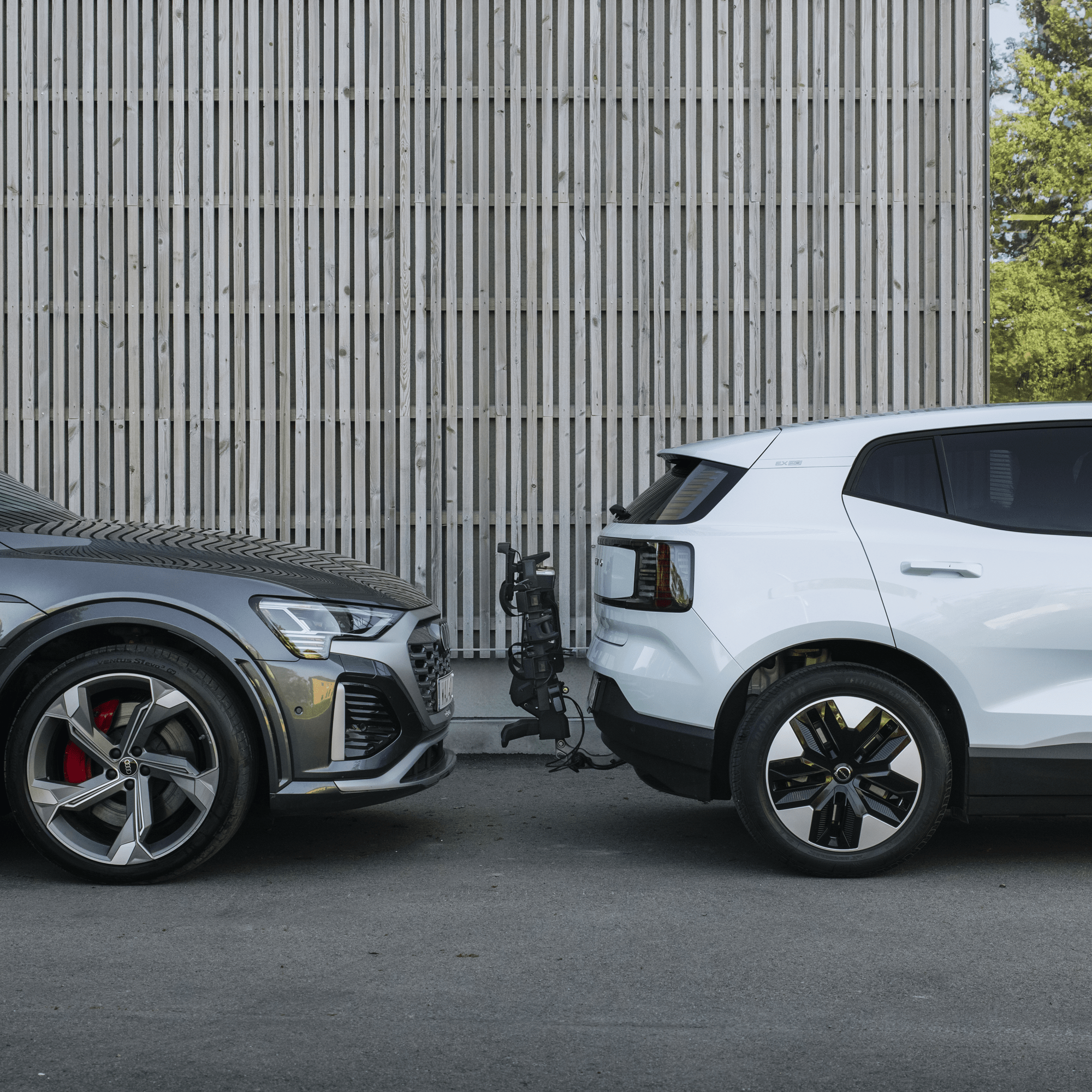 Thule OutPace 2-bike rack attached to a white SUV, with a grey car parked nearby.