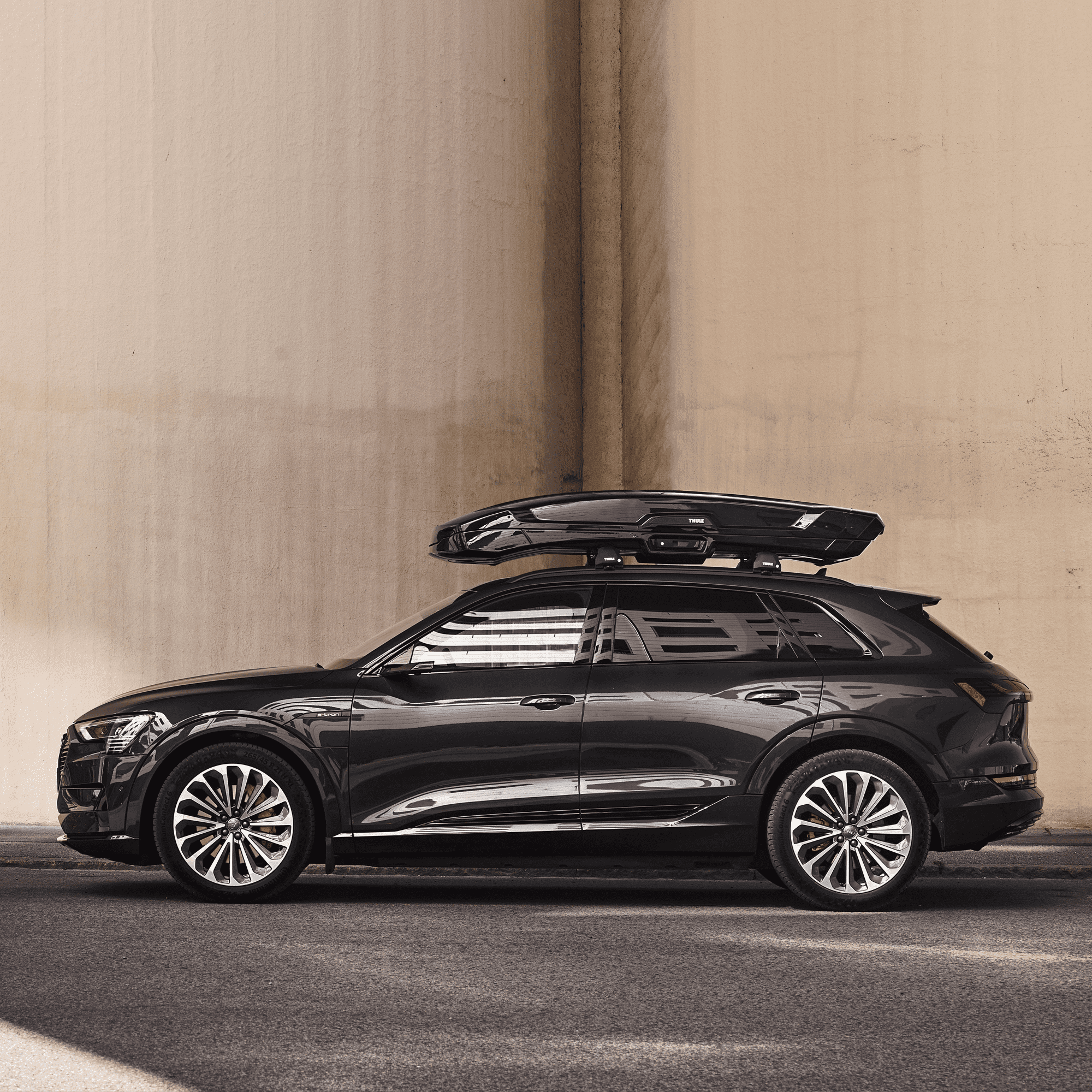 Black Thule Vector Alpine cargo box on a dark SUV, showcasing its sleek, low-profile design.