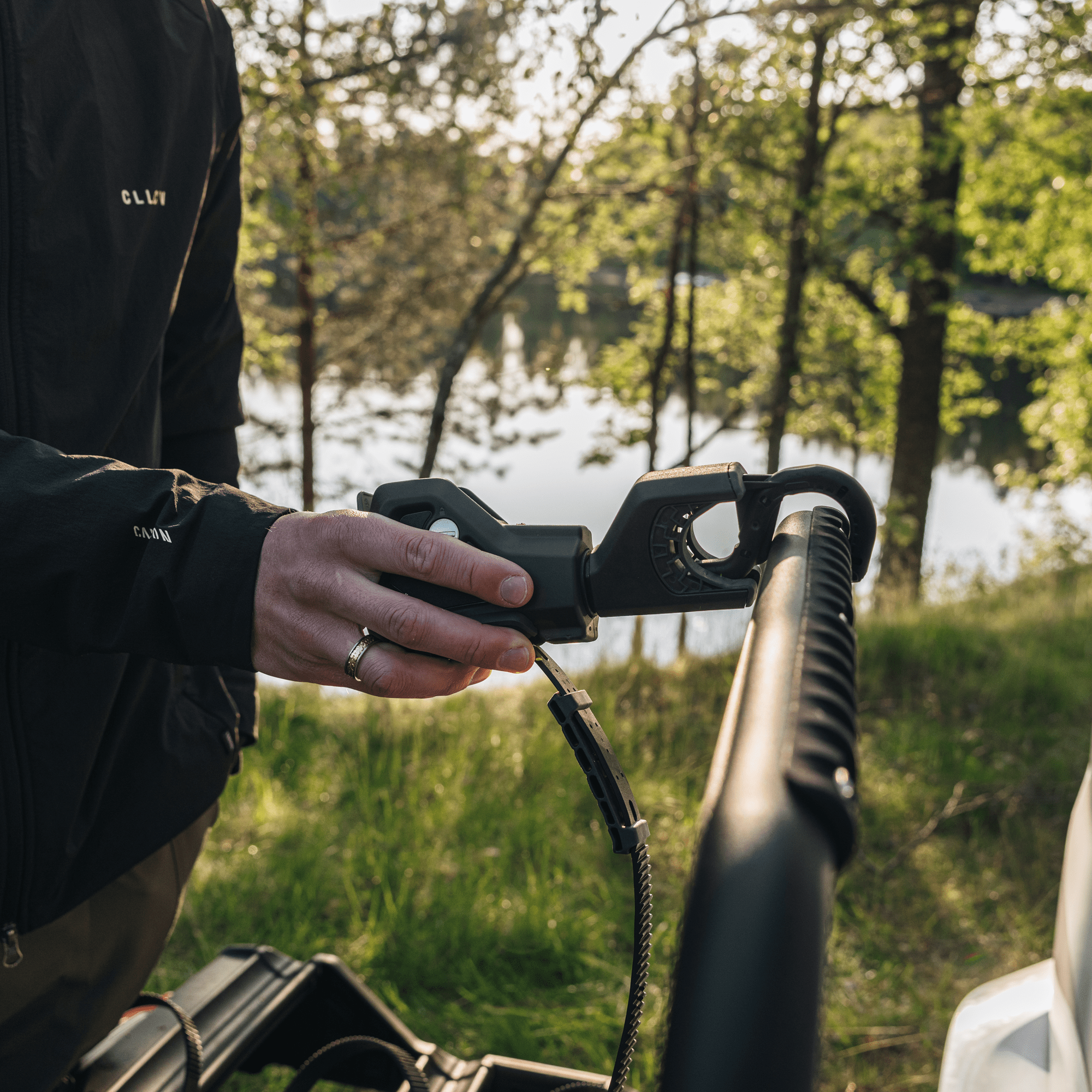 Person attaching a black Thule VeloSpace 3 towbar bike rack, showing its secure locking mechanism.