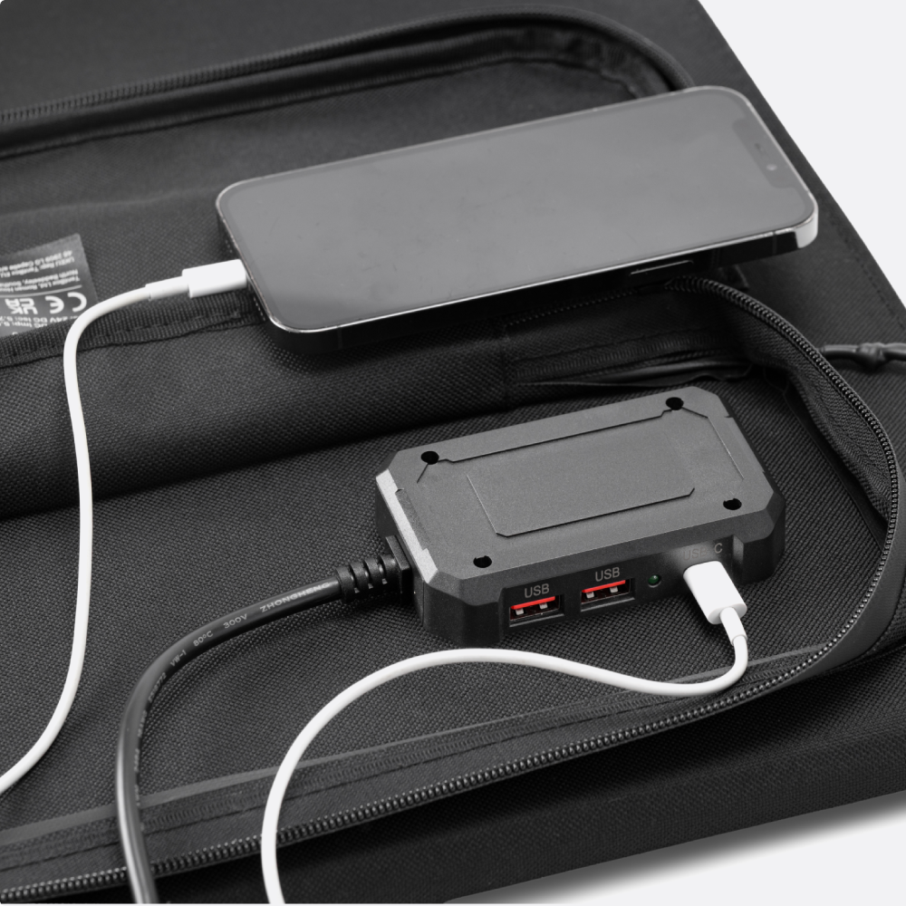 closeup of TentBox Solar Panl on white with mobile phone and devices charging